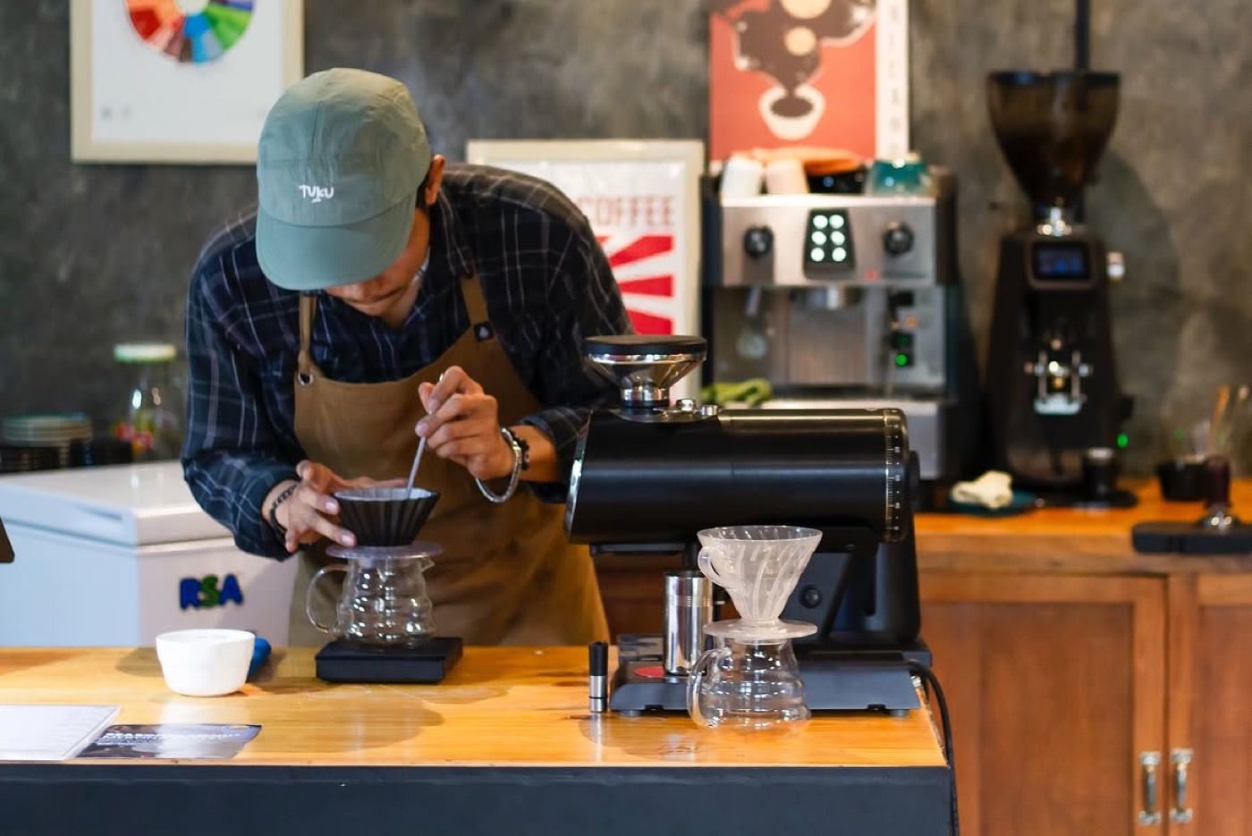 Barista menyeduh V60 di bar Skoee
