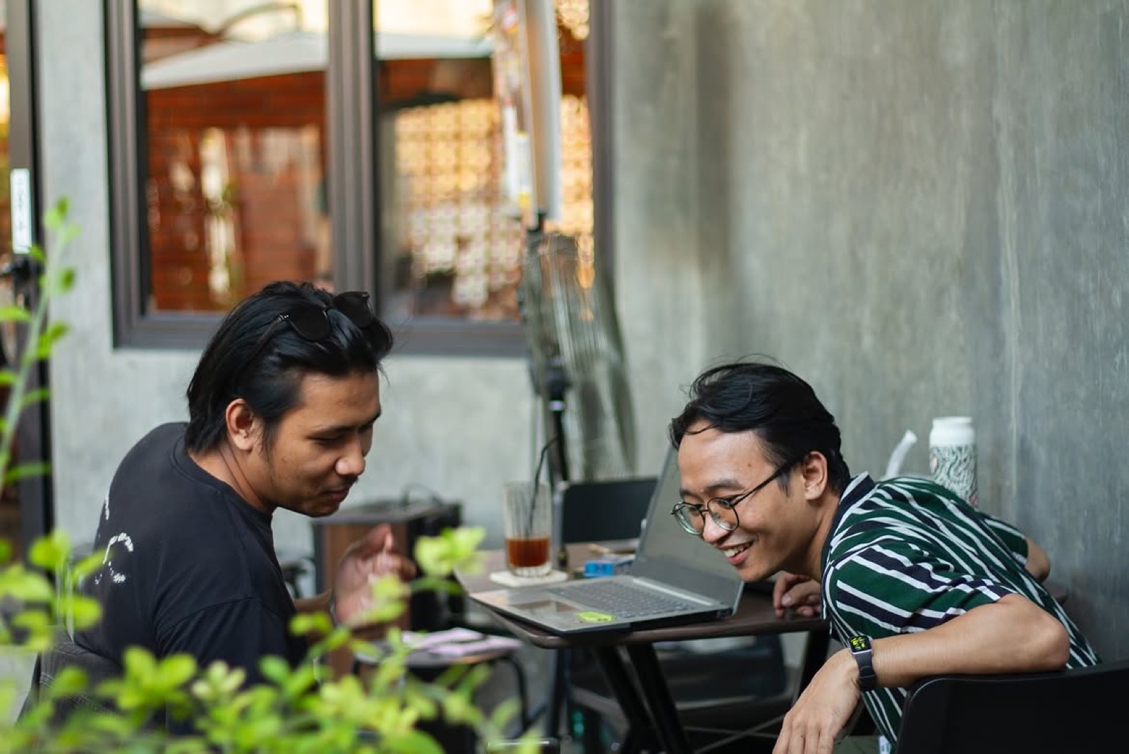 Dua pengunjung berdiskusi di area outdoor Skoee